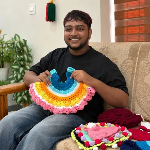 Student holding a rainbow crochet frock
