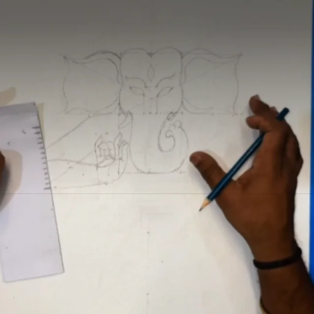 Measuring and sketching the Ganesha outline in pencil with a ruler