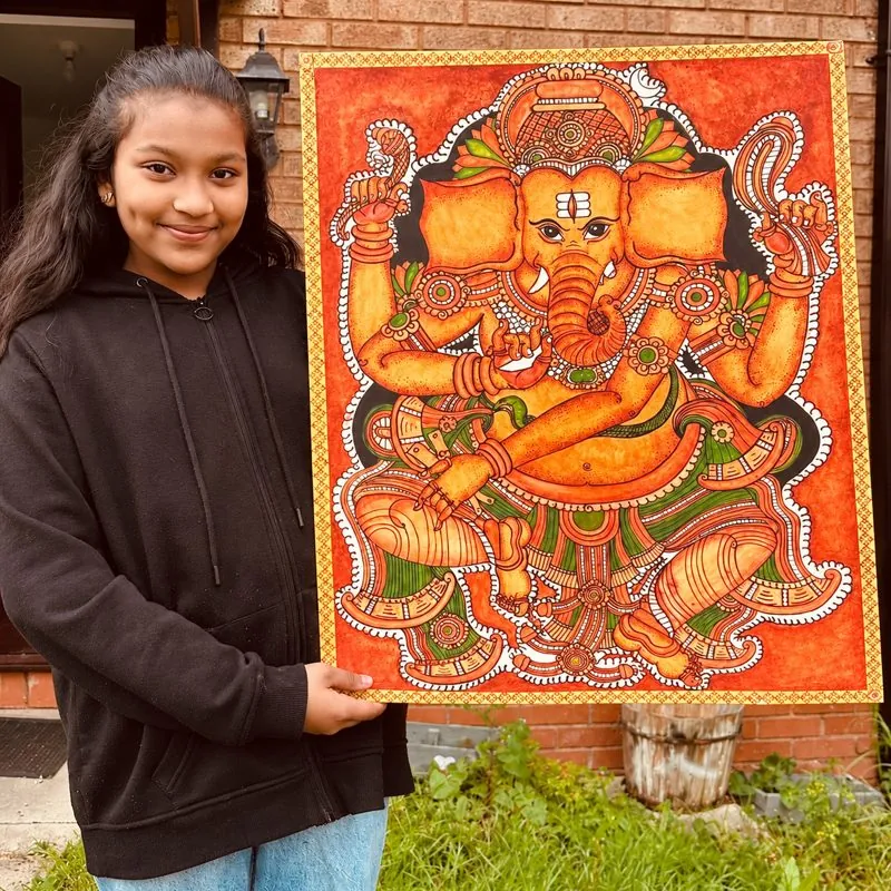 Arushi Abhilash holding her Kerala mural Ganesha painting